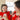 Woman and child in red outfits smiling and holding a cup.